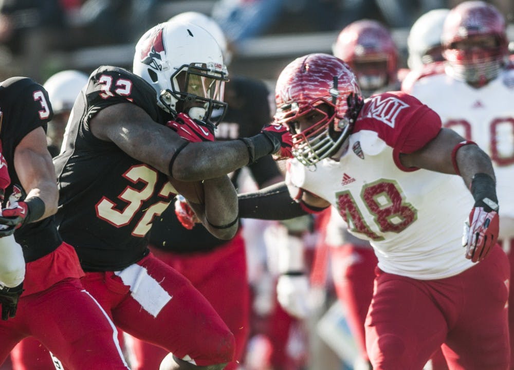 Junior running back Jahwan Edwards pushes aside Miami's Chris Wade on Nov. 29. DN PHOTO JONATHAN MIKSANEK