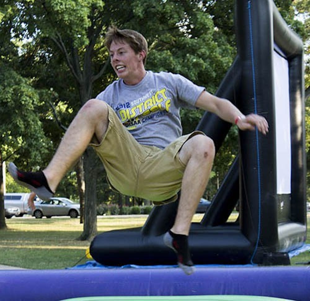 Brandon Groff jumps in a bounce house during the University Program Board Quad Bash on Friday. The event included inflatables and food. DN PHOTO TAYLOR IRBY