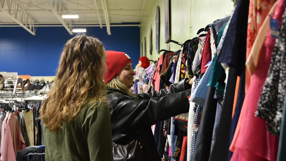 Second-year political science major Payton Glesing (left) and second-year nursing major Elena Mazzei (right) browse in the dress section of the Goodwill on Hessler Road Dec. 1 in Muncie, Indiana. Ella Howell, DN