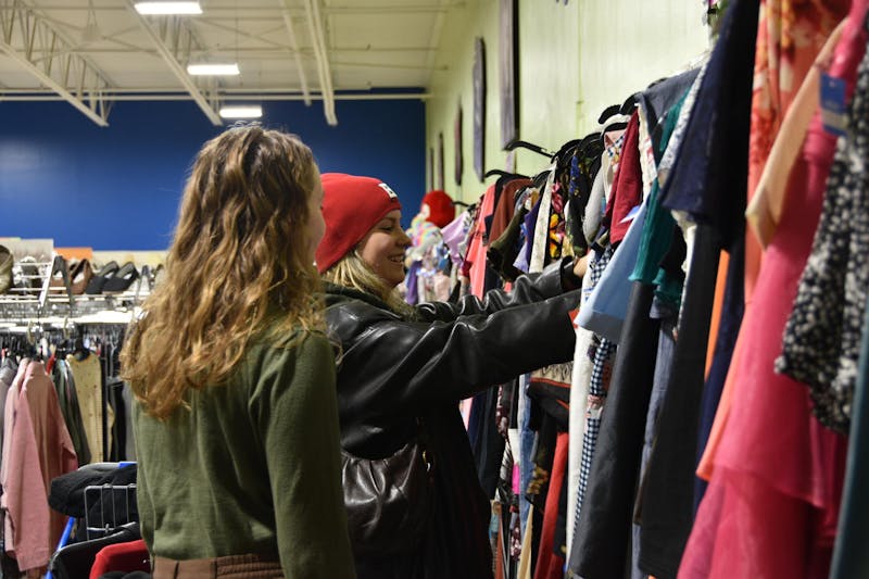 Second-year political science major Payton Glesing (left) and second-year nursing major Elena Mazzei (right) browse in the dress section of the Goodwill on Hessler Road Dec. 1 in Muncie, Indiana. Ella Howell, DN