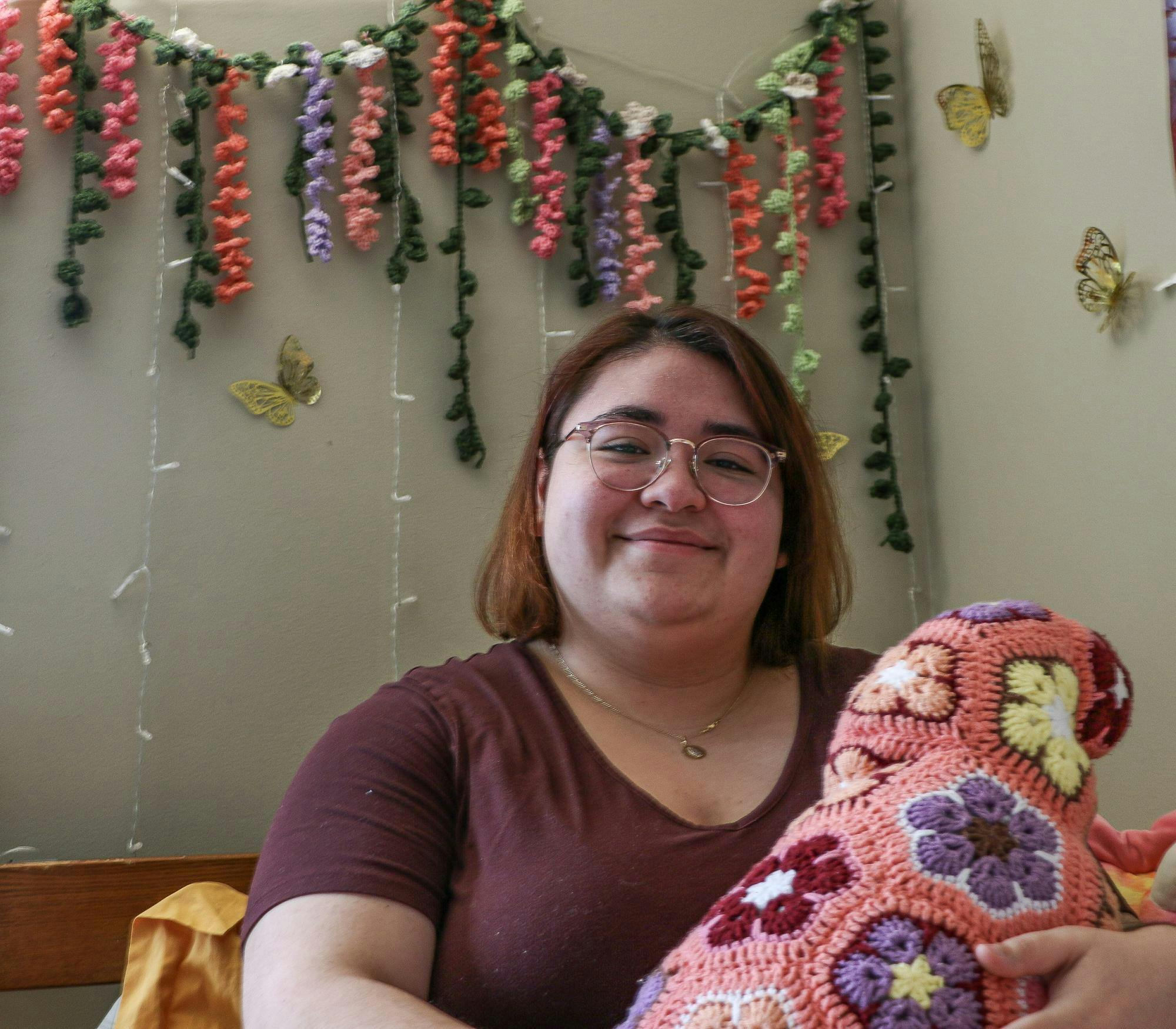 Ball State sophomore Natalia Gonzalez sits on her bed while showing off a crocheted craft she made in her dorm on Feb. 15, 2024, in Muncie, Ind. Cristal Mariano-Vargas, Ball Bearings.