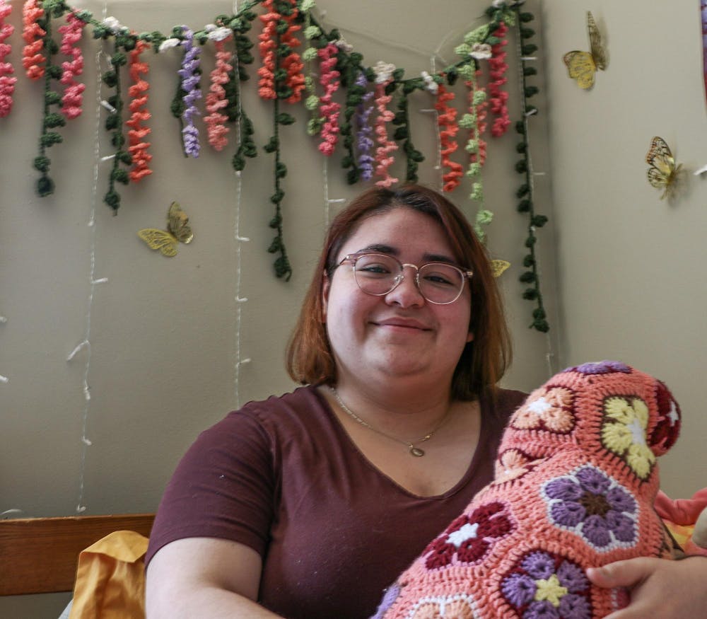 Ball State sophomore Natalia Gonzalez sits on her bed while showing off a crocheted craft she made in her dorm on Feb. 15, 2024, in Muncie, Ind. Cristal Mariano-Vargas, Ball Bearings.