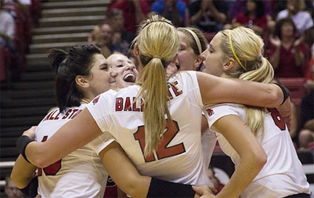 The women’s volleyball team embraces after scoring a point during the match against IPFW on Wednesday. Ball State won 3-2. DN PHOTO EMMA ROGERS