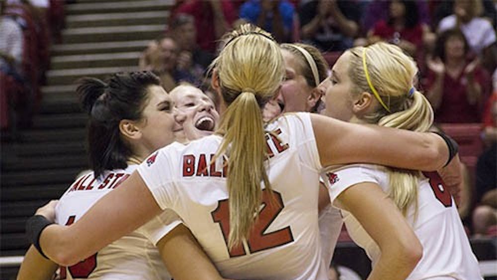 The women’s volleyball team embraces after scoring a point during the match against IPFW on Wednesday. Ball State won 3-2. DN PHOTO EMMA ROGERS