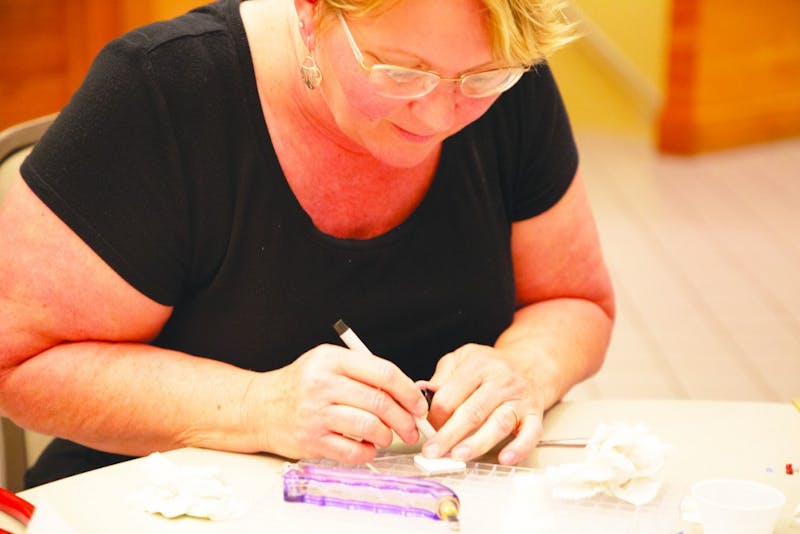 Jackie Davis marks a glass square she is working with to create one of several pieces at a Minnistrista glass workshop Sept. 12, 2019. Alyssa Cooper, DN