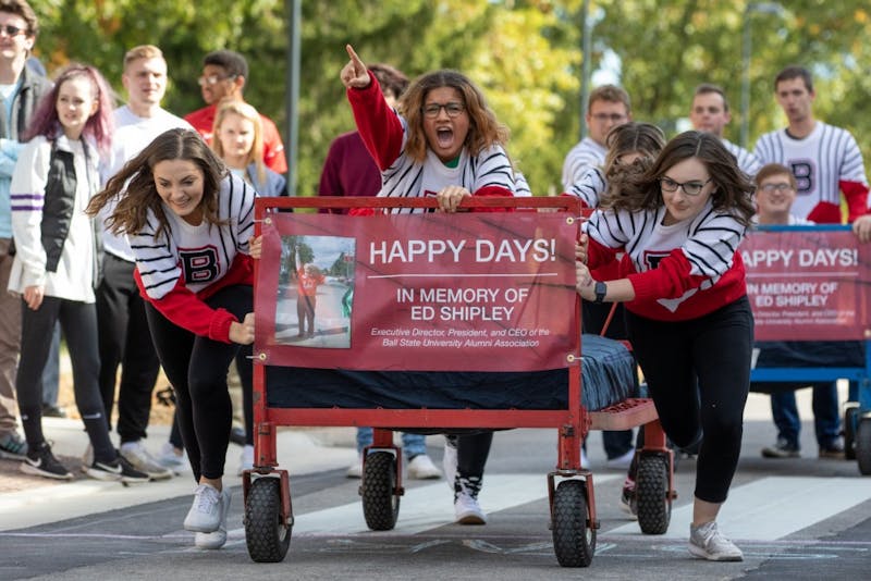 Students from the Ball State University Singers organization take off during the 2019 Ball State University Bed Race Oct. 18, on Riverside Ave. Bed races have been a Homecoming Week traditional at BSU since 1980. Kyle Crawford, Byte File