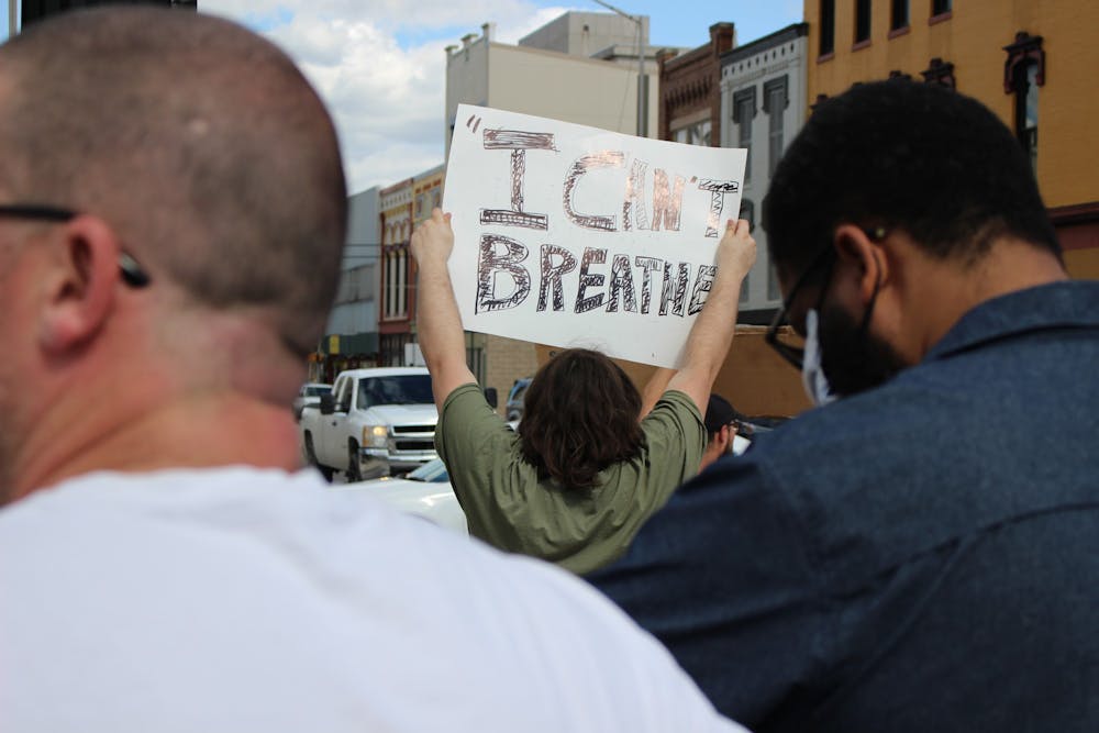<p>Duncan Bellard, a Hartford City, Indiana, resident, holds a sign saying, "I can't breathe," May 30, 2020, near the junction of Walnut and Main streets in downtown Muncie. Bellard came from his hometown, located 30 minutes away, for the protest. <strong>Bailey Cline, DN</strong></p>