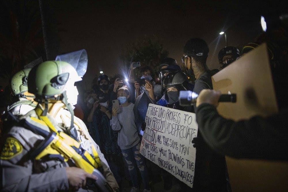 Protesters clash with deputies of the Los Angeles Sheriff's Department during protests following the death of Dijon Kizzee on Monday, Aug. 31, 2020, in Los Angeles, Calif. (AP Photo/Christian Monterrosa)