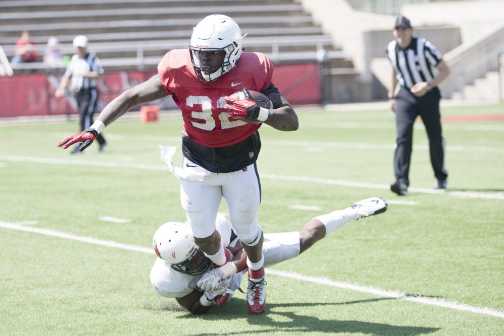 Senior running back Jahwan Edwards gets tackled by a defensive player in the spring football game on April 19 at Scheumann Stadium. Edwards had 13 carries for 26 yards. DN PHOTO JORDAN HUFFER