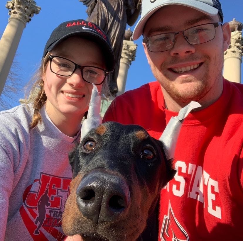 Sophomore Molly Ellenberger and her fiance, Tyler LaFontaine, pose with their dog, Moose, in front of Beneficence. The two got Moose from a breeder in November 2019. Molly Ellenberger, Photo Provided.
