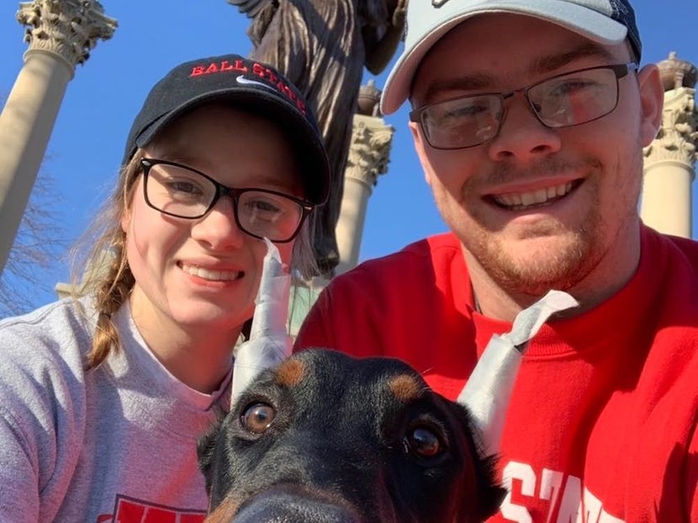 Sophomore Molly Ellenberger and her fiance, Tyler LaFontaine, pose with their dog, Moose, in front of Beneficence. The two got Moose from a breeder in November 2019. Molly Ellenberger, Photo Provided.