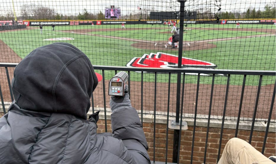 Student Manager, Palmer Phillips tracks the pitch velocity on the radar gun.