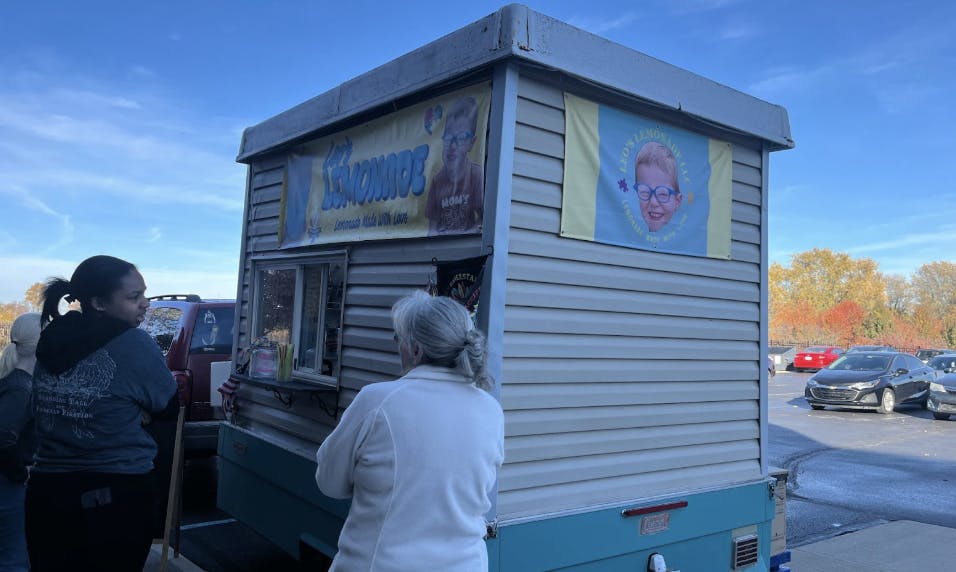 Customers line up outside to order lemonade shake-ups.
