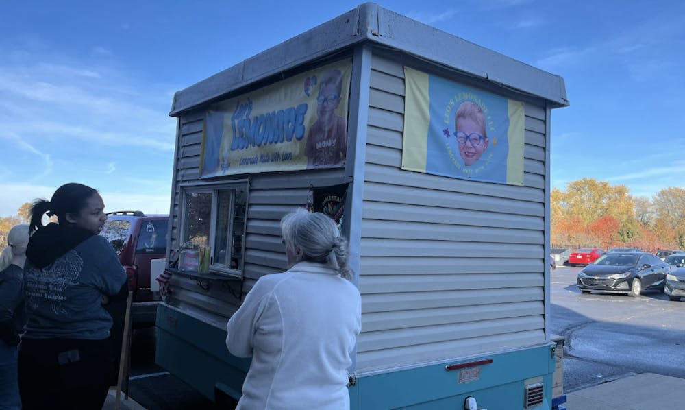 Customers line up outside to order lemonade shake-ups.
