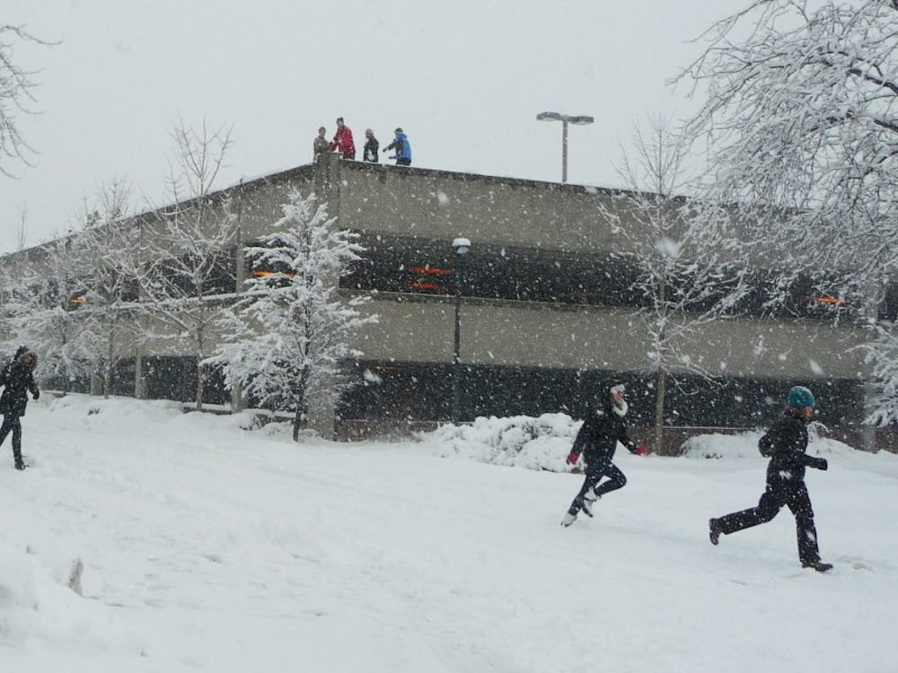 Students atop a parking garage ambush unsuspecting walkers with snowballs. The group said many of their victims played along with the prank. DN PHOTO SAM HOYT