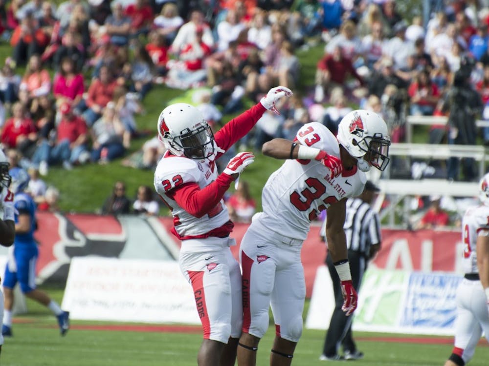 Senior Quintin Cooper and redshirt sophomore Tyree Holder celebrate after a play at the football game against Indiana State on Sept. 13 at Scheumann Stadium. DN PHOTO ALAINA JAYE HALSEY