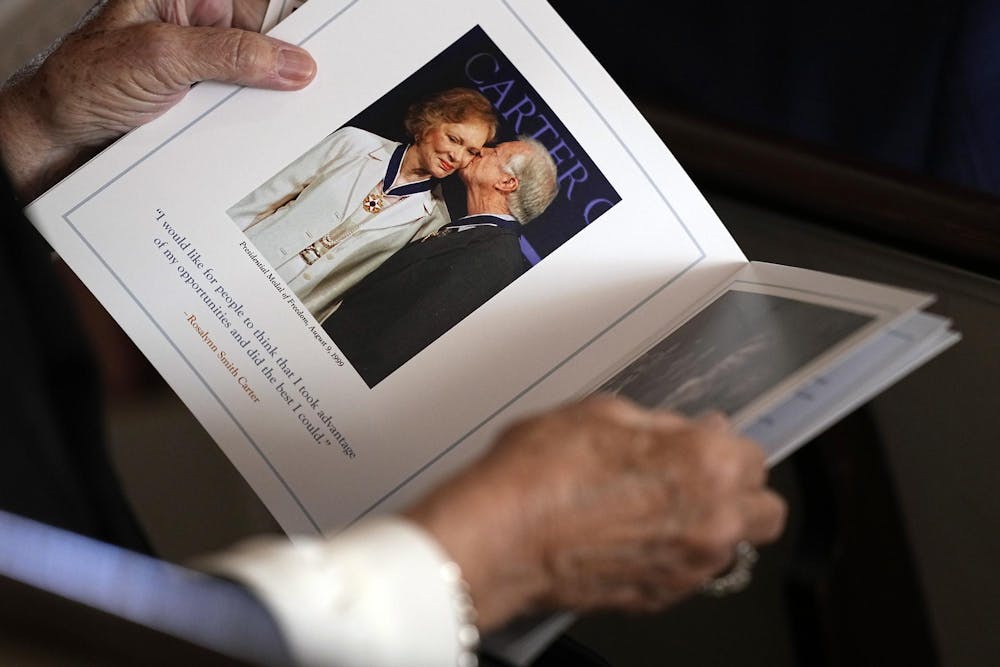ATLANTA, GEORGIA - NOVEMBER 28:  A guest looks at the program before a tribute service for former first lady Rosalynn Carter at Glenn Memorial Church at Emory University on November 28, 2023 in Atlanta, Georgia. Rosalynn Carter, who passed away on November 19 at the age of 96, was married to former U.S. President Jimmy Carter for 77 years. In her lifetime she was an activist and writer known to be an advocate for the elderly, affordable housing, mental health, and the protection of monarch butterflies. (Photo by Brynn Anderson-Pool/Getty Images)