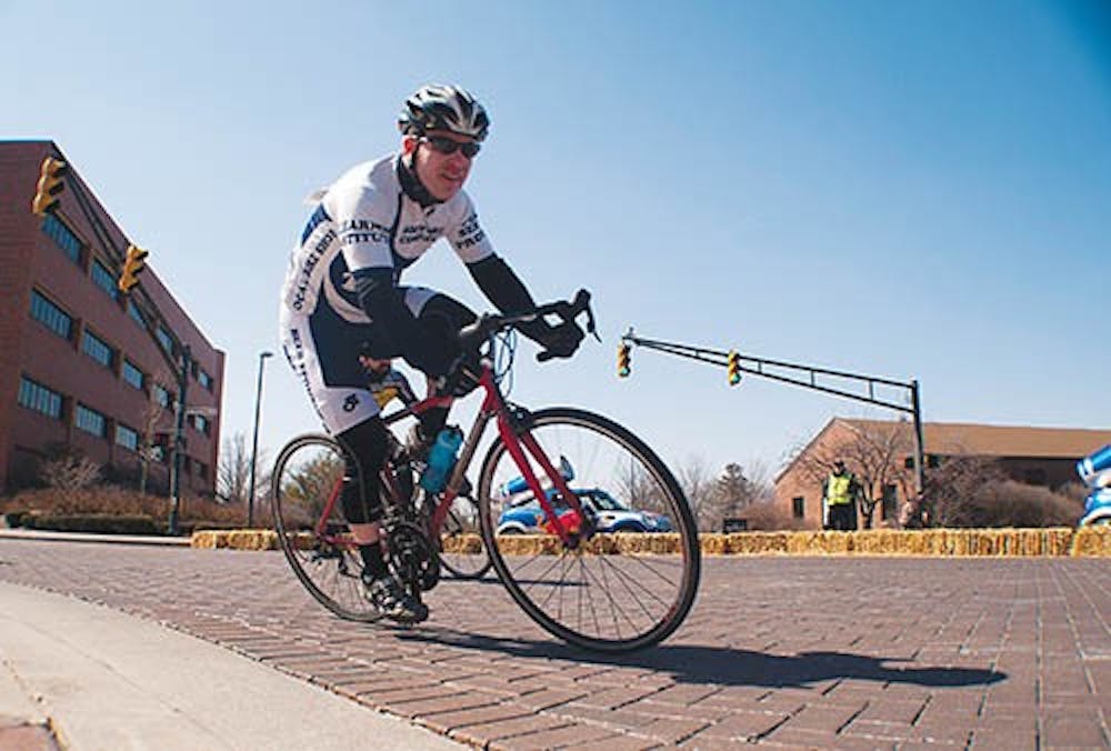 Andy Payne, team member of A Cycling Team, rounds a corner during the last half of the relay race. DN PHOTO BOBBY ELLIS