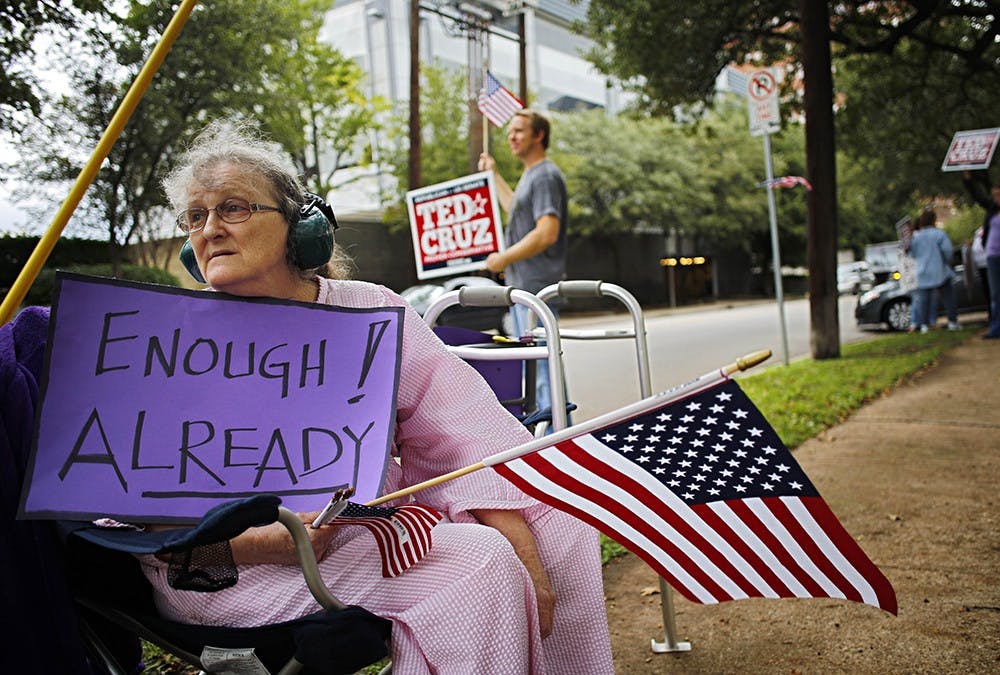 Sheila Helton joins a demonstration outside of the Dallas office of U.S. Sen. Ted Cruz on Tuesday, protesting the federal budget standoff and government shutdown. In the background are Cruz supporters. MCT PHOTO