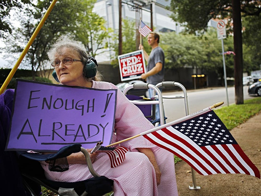 Sheila Helton joins a demonstration outside of the Dallas office of U.S. Sen. Ted Cruz on Tuesday, protesting the federal budget standoff and government shutdown. In the background are Cruz supporters. MCT PHOTO