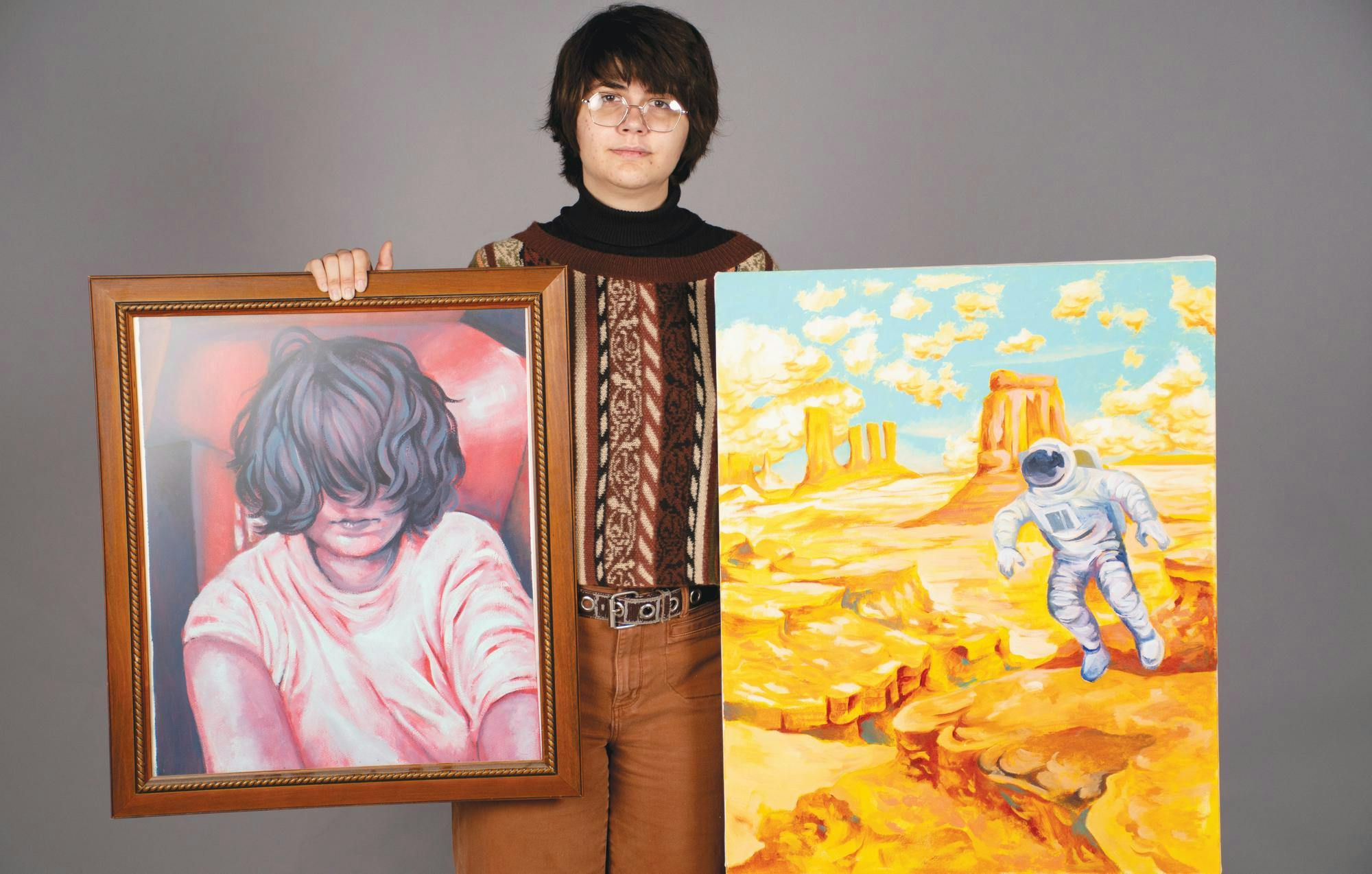 Ball State fourth year Annie Wright poses for a photo with their device they use to do their art as well as two of the paintings they have completed Nov. 20 in the Arts and Journalism Building. Kadin Bright, DN