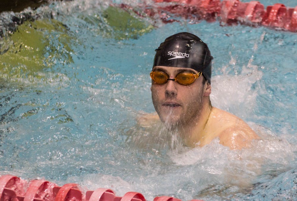 Senior Bradley Ridge checks the scoreboard after swimming butterfly during the senior meet against Notre Dame on Feb. 4 in Lewellen Pool. The men's swim and dive team lost 82.5-148.5. Grace Ramey // DN