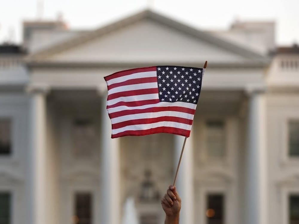 In this 2017 file photo, a flag is waved outside the White House, in Washington. The Trump administration announced Friday that it was curbing legal immigration from six additional countries. (AP Photo/Carolyn Kaster)