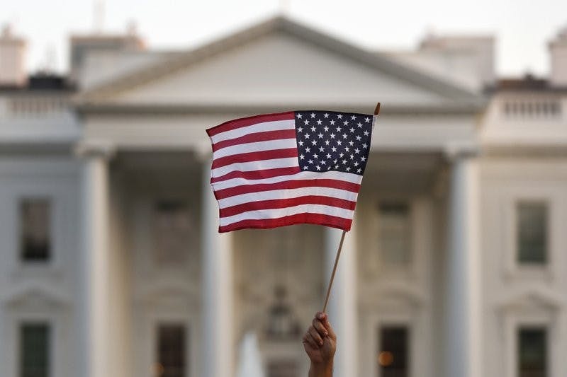 In this 2017 file photo, a flag is waved outside the White House, in Washington. The Trump administration announced Friday that it was curbing legal immigration from six additional countries. (AP Photo/Carolyn Kaster)