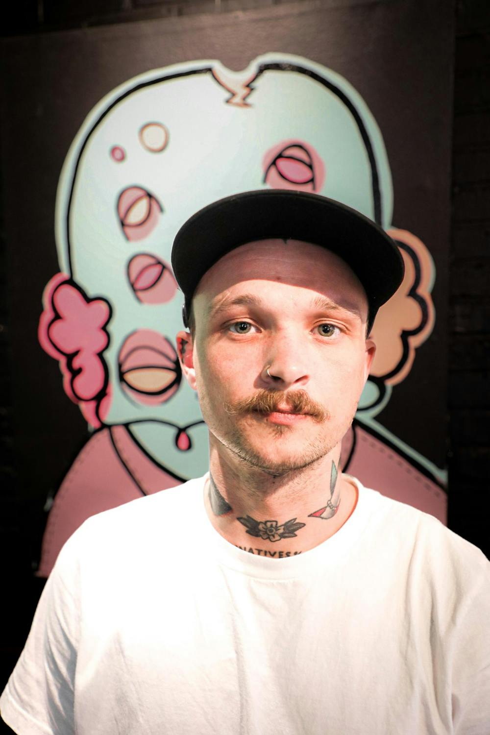 <p>Muncie based artist Zorn Crowder poses for a photo in front of his work April 2 at The Cup. Andrew Berger, DN&nbsp;</p>