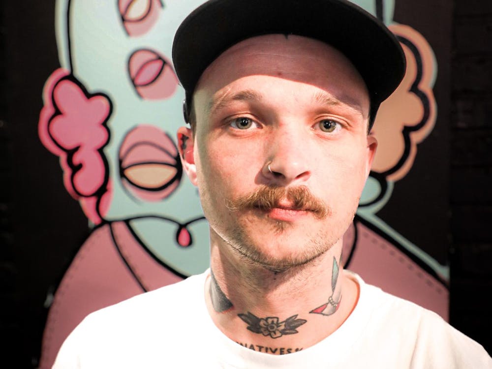 Muncie based artist Zorn Crowder poses for a photo in front of his work April 2 at The Cup. Andrew Berger, DN 