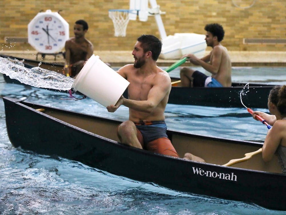 Freshman Peter Sherfey throws water across the pool while freshman Lexi Leisure uses a super soaker to squirt water into another team’s canoe Feb. 5, 2020, at Ball Gymnasium pool. Their team, Exes and Flexes, won the event. Hannah Gunnell, DN