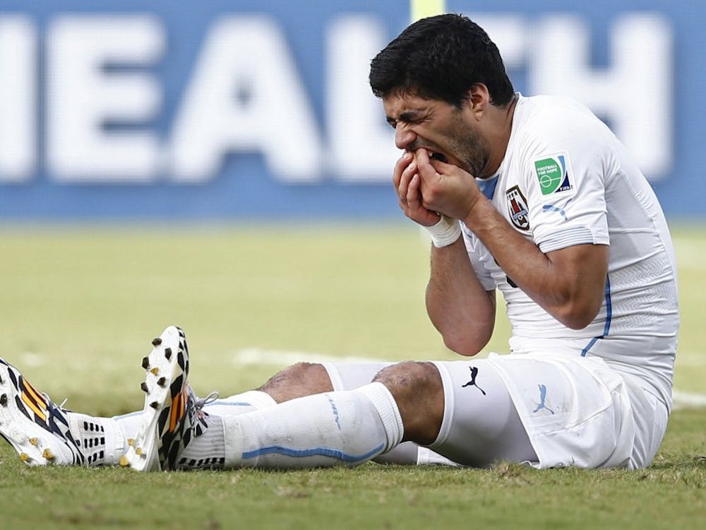 Uruguay's Luis Suarez holds his teeth after appearing to bite Italy's Giorgio Chiellini during FIFA World Cup in Natal, Brazil, on June 24, 2014. (Andrew Boyers/Action Images via Zuma Press/MCT)