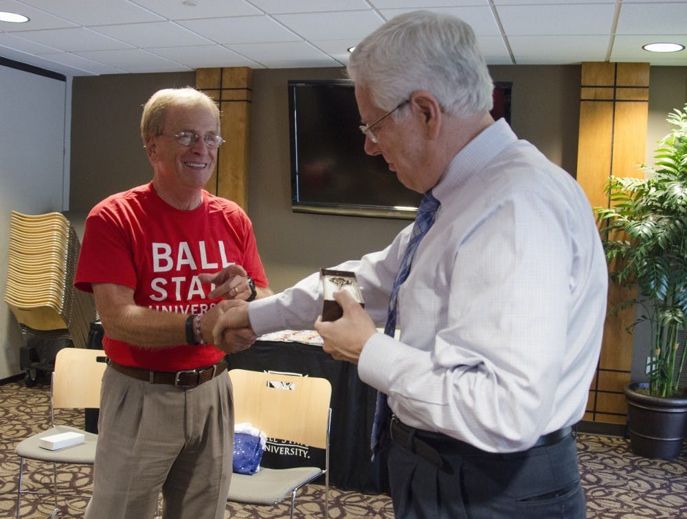 Muncie Mayor Dennis Tyler hands Ball State President Paul Ferguson a key to the city on Sept. 18 at the Cardinal Hall C. Tyler informed Ferguson that he is now an honorary deputy mayor of Muncie. DN PHOTO BREANNA DAUGHERTY 