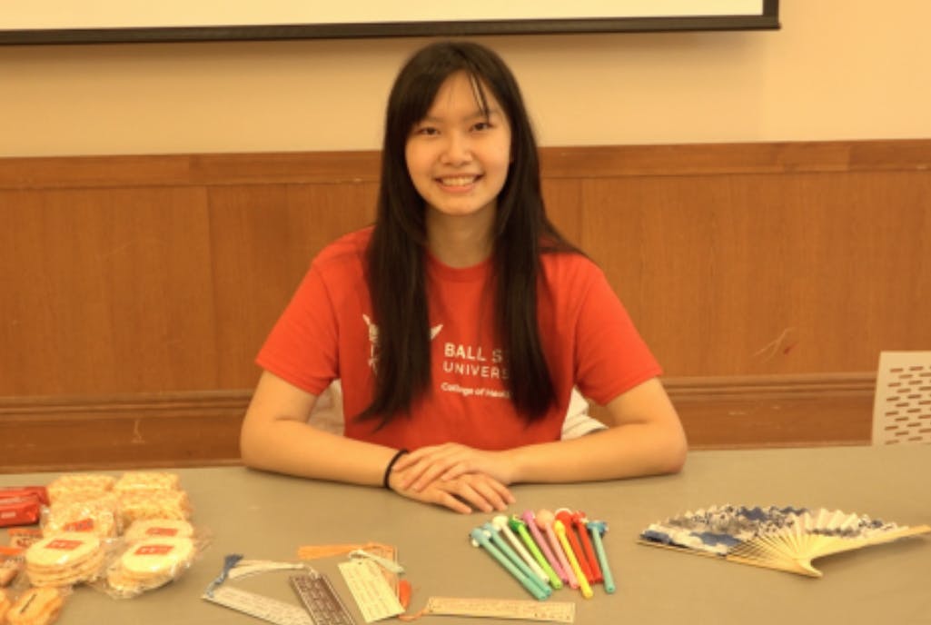 Student representative hosts a table at the pizza party.