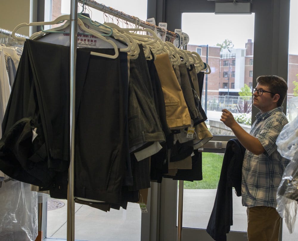 <p>Hayden Brucker, third-year Ball State media major, looks for business attire in Park Residence Hall on Sept. 13, 2022. The business attire came from Cardinal Closet which the Ball State Student Action Team brings through donations. Maya Kim, DN</p>