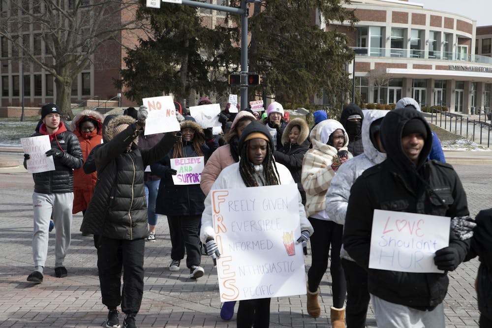 Protesters cross the scramble light holding signs during the Walk A Mile In Her Shoes event March 18. The event was hosted by Black Women’s Voices. Olivia Ground, DN