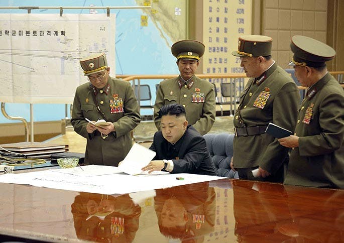 A photo provided by Korean Central News Agency (KCNA) shows North Korean leader Kim Jong Un, center, on March 29, 2013, signing an order putting rockets on standby after an urgent meeting with top generals. (KCNA/Xinhua/Zuma Press/MCT)