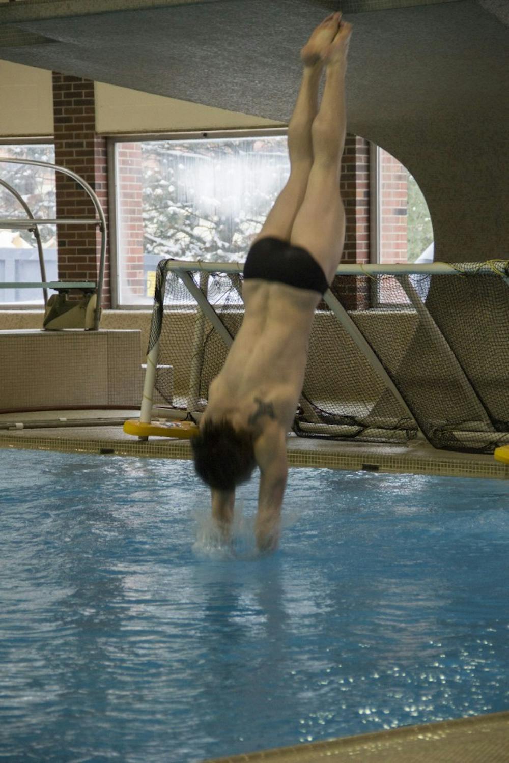 Jacob Brehmer, a senior, dives during the meet against Miami on Feb. 8 at the Lewellen Aquatic Center. DN PHOTO EMMA ROGERS