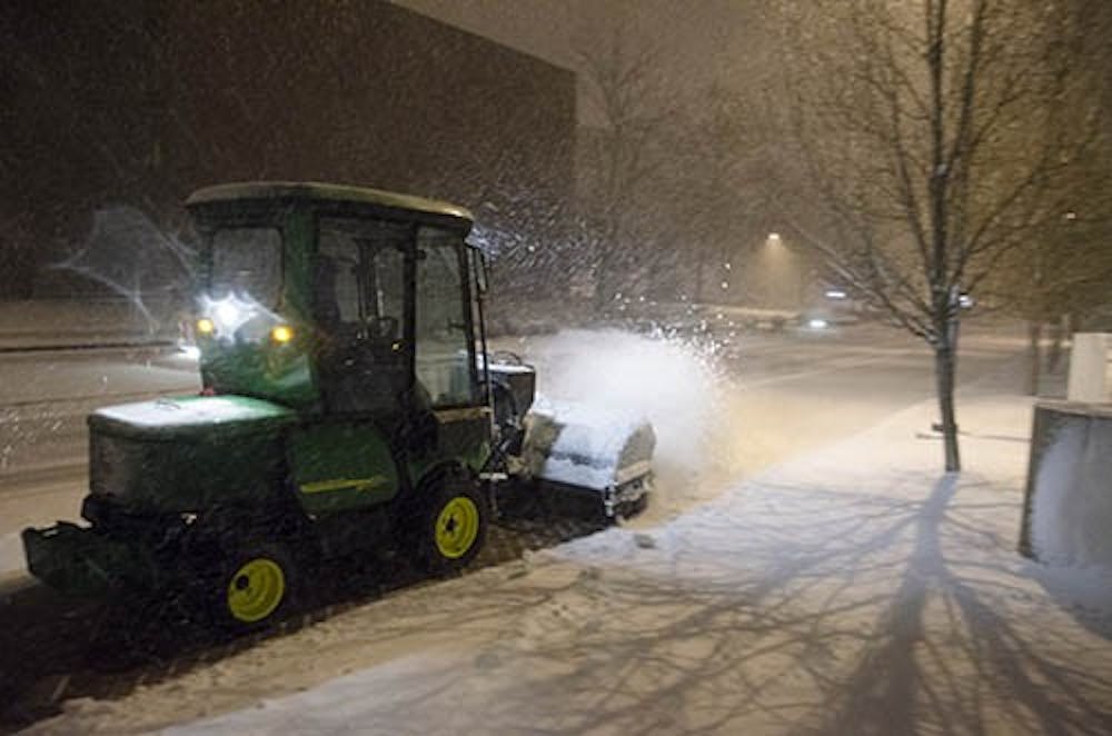 Snow removers try to keep up with falling snow Sunday evening as a winter storm advisory is placed on central Indiana. DN PHOTO COREY OHLENKAMP