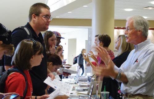 Timothy Berg, an assistant professor of history, talks to students Erin Bretz and Matthias Dorau about the study abroad options that are open to all students on Sept. 12, 2012. Spring Semester’s study abroad fair is open 10 a.m. to 3 p.m. Jan. 16, 2013. PHOTO PROVIDED BY GINA PORTOLESE