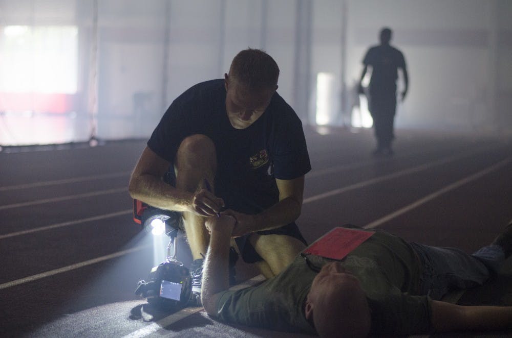 Muncie firefighter Austin Rich marks a volunteer victim during the crisis drill June 7 at the Field Sports Building. Emergency medical services and firefighters used the drill to learn how to handle an emergency situation. DN PHOTO BREANNA DAUGHERTY