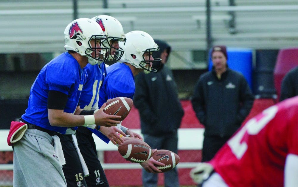 Junior Kyle Kamman, sophomore Ozzie Mann and sophomore Jack Milas receive a tandem snap in a drill during spring practice. All three are competing to replace the spot left by Keith Wenning. DN PHOTO LAUREN CHAPMAN