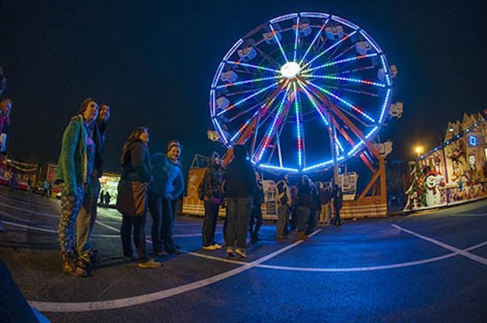 Students wait in line for the ferris wheel during the Late Nite Carnival. The ferris wheel closed down for a stretch of time due to the whether. DN PHOTO JONATHAN MIKSANEK