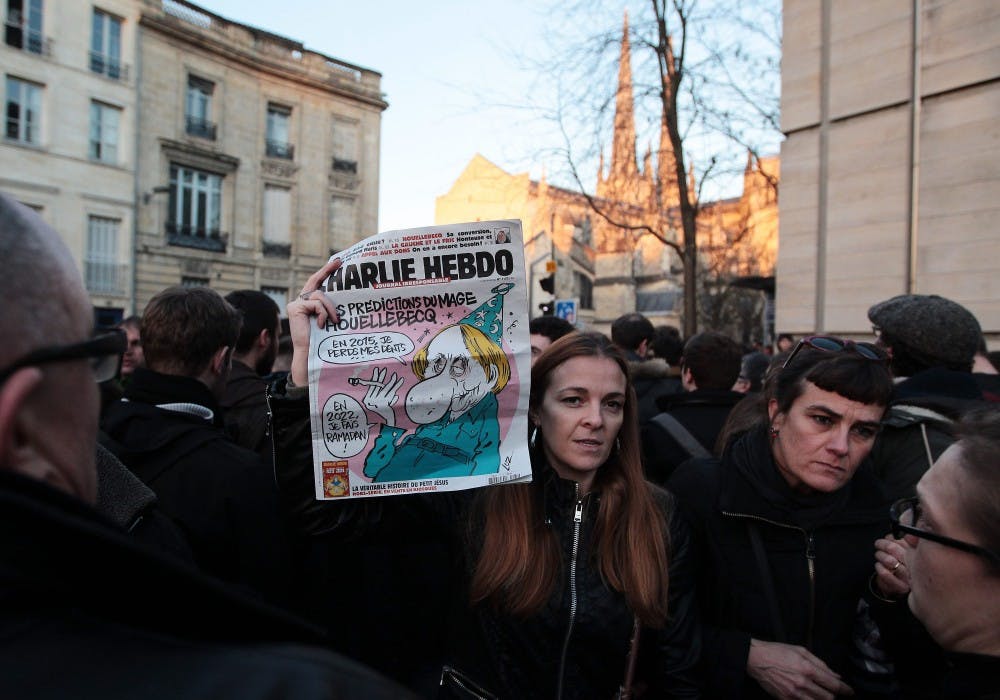 People hold up tributes to the victims of the Charlie Hebdo shooting on Jan. 7 during a 1-minute silence in Bordeaux, France, in remembrance of those killed and wounded in the deadly attack in Paris on Wednesday. Gunmen killed 12 people at the Paris office of French satirical magazine Charlie Hebdo in an apparent militant Islamist attack. Four of the magazine