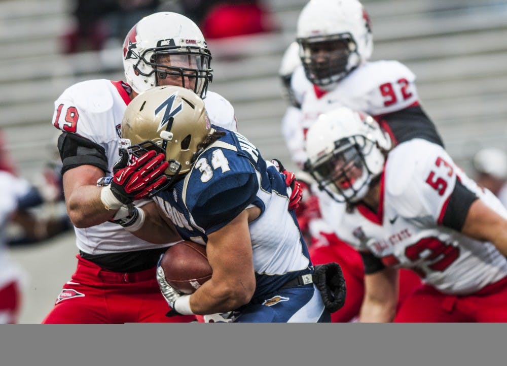 Sophomore linebacker Ben Ingle attempts to bring down the University of Akron ball carrier Conor Hundley on Oct. 26. DN PHOTO JONATHAN MIKSANEK