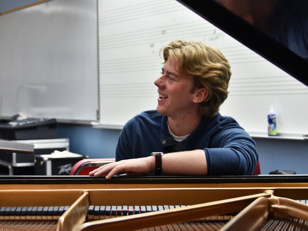 First-year jazz studies major Nick Engle laughs with other members of the band while he plays the piano in rehearsal Oct. 26 in the Hargreaves Music Building. The band says having a pianist helps complete their overall sound. Ella Howell DN