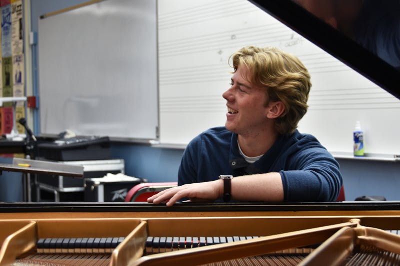 First-year jazz studies major Nick Engle laughs with other members of the band while he plays the piano in rehearsal Oct. 26 in the Hargreaves Music Building. The band says having a pianist helps complete their overall sound. Ella Howell DN