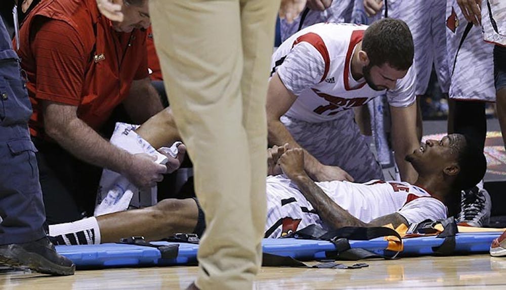 Louisville teammates gather around teammate Louisville guard Kevin Ware (5) after he broke his right leg in first half action in the NCAA regional final game on Sunday, March 31, 2013, in Indianapolis, Indiana. Louisville won the game 85-63. Ware was taken to IU Health Methodist Hospital from the floor. Louisville won the game 85-63. (Sam Riche/MCT)