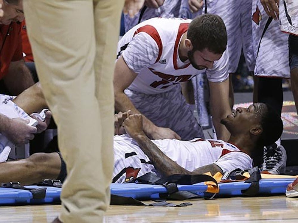 Louisville teammates gather around teammate Louisville guard Kevin Ware (5) after he broke his right leg in first half action in the NCAA regional final game on Sunday, March 31, 2013, in Indianapolis, Indiana. Louisville won the game 85-63. Ware was taken to IU Health Methodist Hospital from the floor. Louisville won the game 85-63. (Sam Riche/MCT)