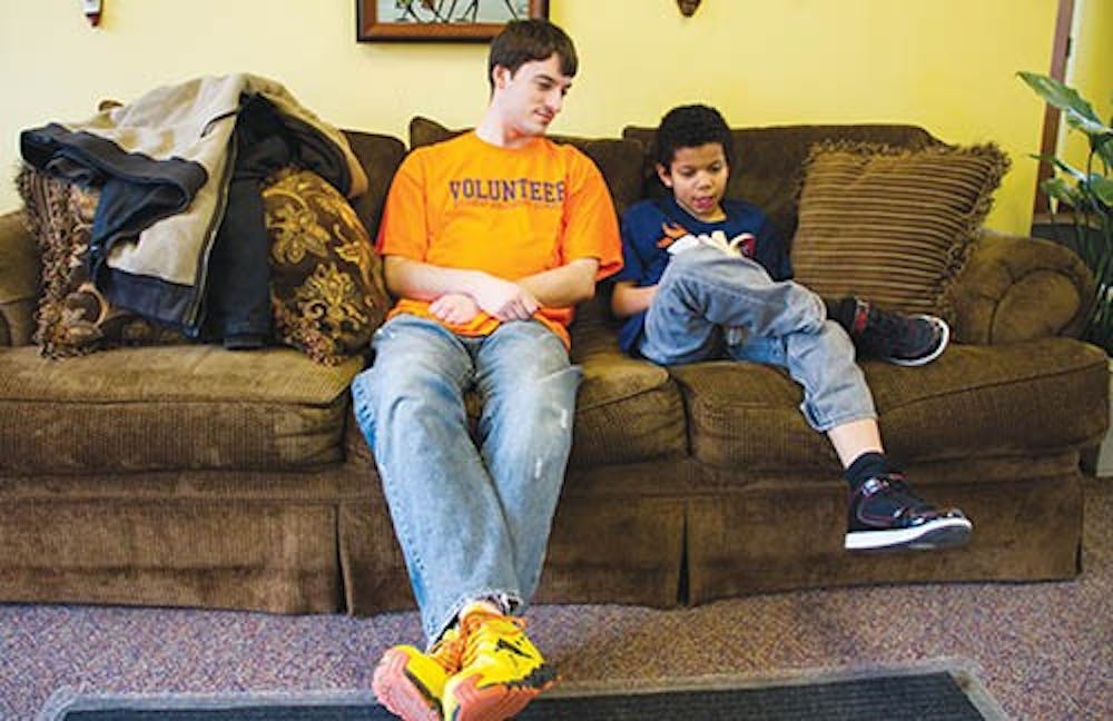 Motivate Our Minds volunteer James Simmons spends his time outside of being a student at Ball State to help nine-year-old Jeffrey Hawkins read “Harry Potter.” DN PHOTO HANNA JACKSON